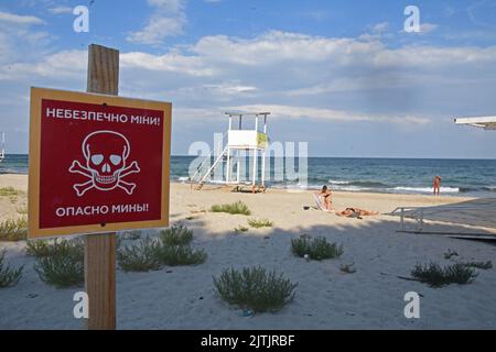 Odessa, Ukraine. 10. August 2022. Im August 2022 gehen Menschen in Odessa, Ukraine, an einem Strand mit Warnschildern schwimmen, die darauf hinweisen, dass es sich um meine Sünde im Wasser handelt. Odessa war ein beliebter Touristenort zum Schwimmen und einen Tag am Strand vor der russischen Invasion. Jetzt schwimmen die Menschen auf eigenes Risiko, da Minen angelegt wurden, um sich gegen Vorstöße des russischen Militärs aus dem Schwarzen Meer zu verteidigen. (Foto: Teun Voeten/Sipa USA) Quelle: SIPA USA/Alamy Live News Stockfoto