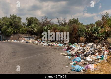 Am Straßenrand auf dem Ätna, Sizilien, Italien, werden Haufen inländischer Abfälle deponiert. Dies ist eine sehr verbreitete Ansicht in ländlichen Gebieten Stockfoto