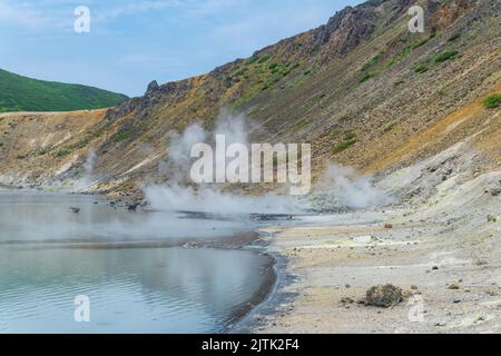 Heißer mineralisierter See mit Thermalquelle und rauchenden Fumarolen in der Caldera des Vulkans Golovnin auf der Insel Kunashir Stockfoto