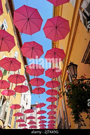 Rosa Regenschirme über der Straße, Grasse France Stockfoto