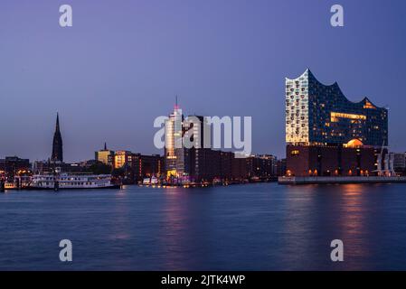 Die Elbe-Philharmonie im Hamburger Hafen leuchtet in der goldenen Stunde der Dämmerung, Hamburg, Deutschland Stockfoto