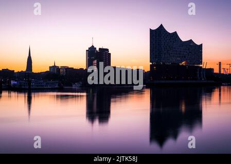 Die Elbphilharmonie und die Hamburger Skyline spiegeln sich in der Elbe im Morgengrauen, Hamburg, Deutschland Stockfoto