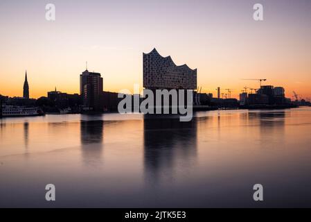 Die Elbphilharmonie und die Hamburger Skyline spiegeln sich in der Elbe im Morgengrauen, Hamburg, Deutschland Stockfoto