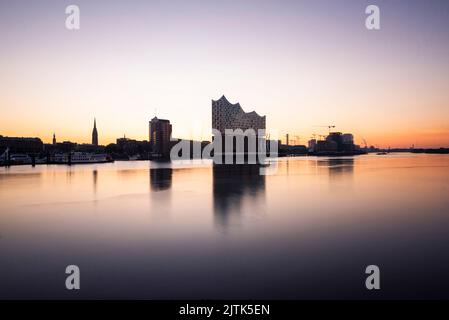 Die Elbphilharmonie und die Hamburger Skyline spiegeln sich in der Elbe im Morgengrauen, Hamburg, Deutschland Stockfoto