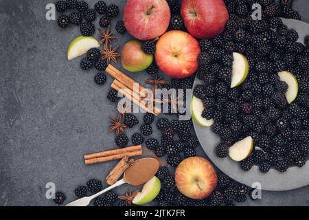 Geernte Brombeeren und Äpfel mit Zimt und Sternanisgestein auf Schiefer Stockfoto
