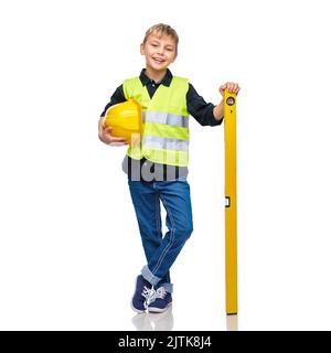 Junge im Bau Helm und Weste mit Niveau Stockfoto