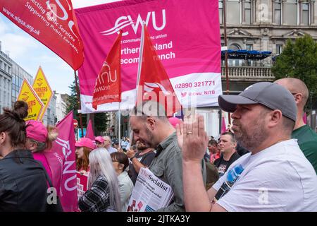 Belfast, Großbritannien. 31. August 2022. Man begrüßt die Rede, während sich Aktivisten vor dem Rathaus von Belfast versammeln, um angesichts der steigenden Lebenshaltungskosten während der NI Strike Rally der Communication Workers Union für bessere Bezahlung zu plädieren. CWU-Flaggen und gewerkschaftsbanner schwenken. Quelle: Steve Nimmons/Alamy Live News Stockfoto