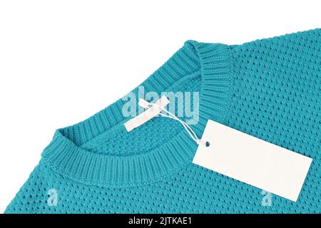 Weiße leere rechteckige Kleidung Tag, Label Mockup Vorlage auf türkis gestrickt Pullover isoliert auf weißem Hintergrund . Preisschild mit Kopie-Aufkleber Stockfoto