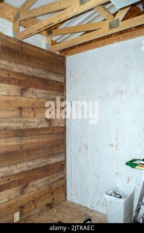Ein neuer Raum befindet sich in der Bauphase. Rustikale Wände und Dekor werden den Farmhouse-Effekt hervorheben. Viel Speicherplatz für Kopien. Gute Werbung für Bau Stockfoto