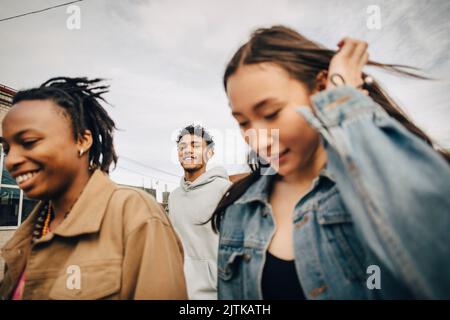 Lächelnder junger Mann mit multirassischen Freundinnen Stockfoto