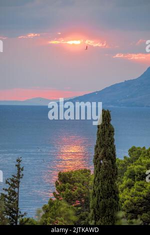 Kroatische Küste gegen Sonnenuntergang mit Adria in der Nähe Brela Stadt in Makarska riviera, Dalmatien, Kroatien Stockfoto