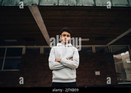 Portrait der junge Mann stand mit verschränkten Armen Stockfoto