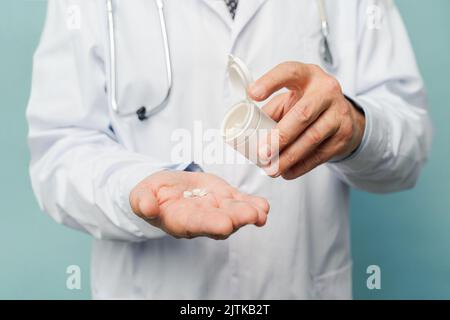 Arzt Pillen in seiner Hand gießen Stockfoto