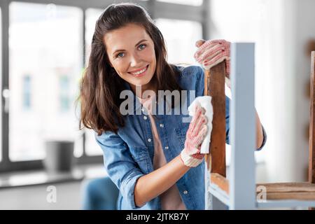 Frau, die die alte Tischoberfläche mit Gewebe reinigt Stockfoto