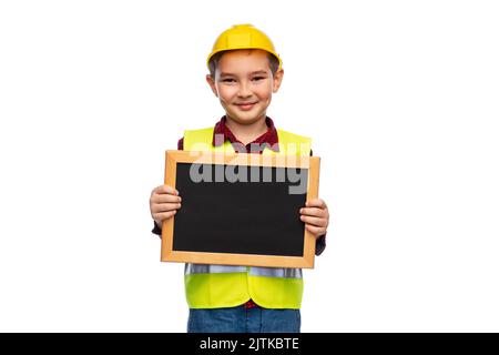 Kleiner Junge in Schutzhelm mit Kreidetafel Stockfoto