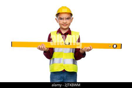 Junge im Bau Helm und Weste mit Niveau Stockfoto