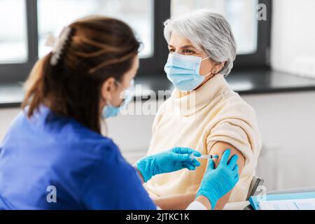 Krankenschwester mit Spritze, die der Frau Injektion macht Stockfoto