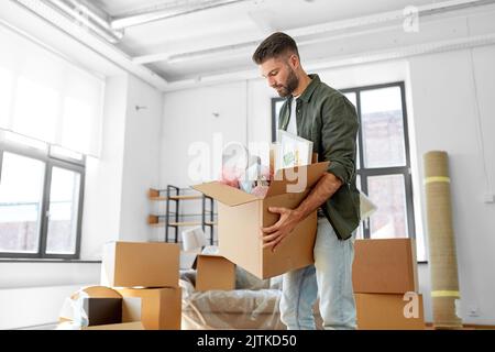 Mann mit Kisten zieht in ein neues Zuhause Stockfoto