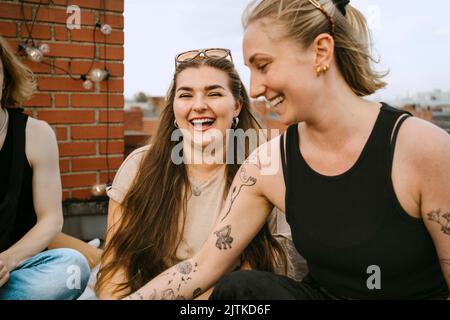 Fröhliche Freundinnen, die auf dem Dach Spaß haben Stockfoto