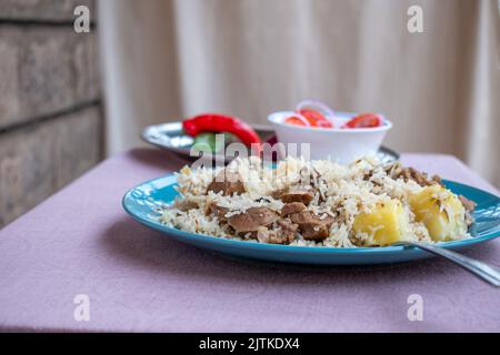 Eine Platte mit kenianischem Pilau auf Tischhöhe. Stockfoto