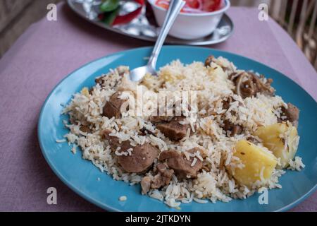 Ein Teller kenianischer Pilau aus der Perspektive eines Abendessens. Stockfoto