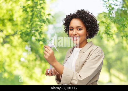 Glückliche Frau mit Spielzeug-Windturbine Stockfoto