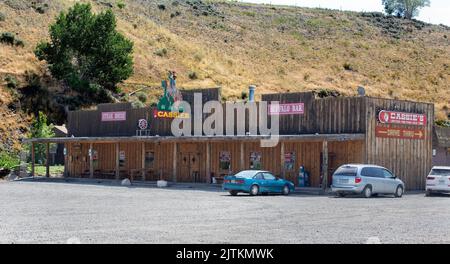 Außenansicht eines Old West-Geschäfts mit Bar, Lounge, Steakhaus mit Neonschild und Drive-Thru-Spirituosen in Cody, Wyoming. Stockfoto