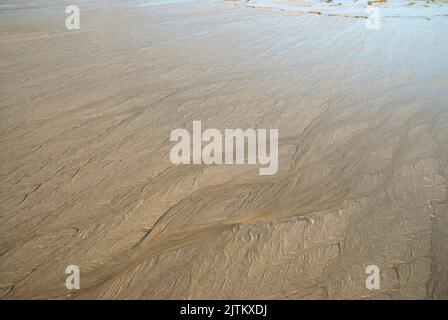 Nahaufnahme eines Strands bei Ebbe. Wird spät am Tag eingenommen, da die Sonne untergeht. Stockfoto