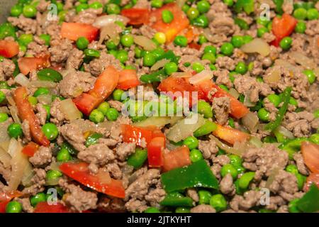 Hackfleisch, Erbsen, grüne Paprika und Tomaten in Brasilien in einer Pfanne gehackt. Stockfoto