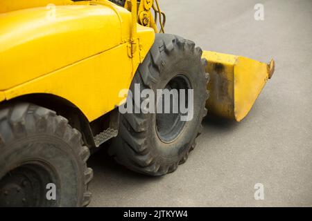 Gelbe Mini-Planierraupe. Kleine Baumaschinen. Dieseltransport. Gelbes Förderband. Stockfoto