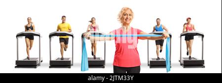 Reife Frau, die mit einem Gummiband trainiert, und Menschen, die auf Laufbändern auf weißem Hintergrund laufen Stockfoto