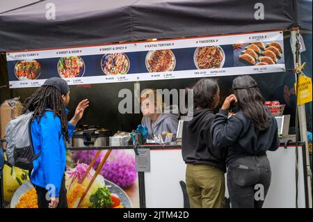 LONDON - 20. Mai 2022: Frau bedient Kunden am Pop-up-Street-Food-Stand auf der South Bank Stockfoto