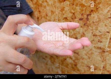 Weiße Frau Hand Putting Alkohol Gel zum Schutz gegen Coronavirus in Rio de Janeiro. Stockfoto