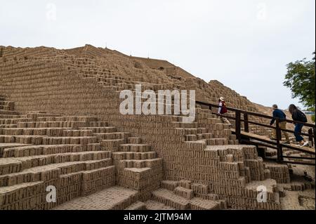 Ein Reiseleiter führt die Touristen die Stufen des Pyramidenabschnitts der historischen Ruinen von Huaca Pucllana hinauf. Der Komplex befindet sich in Miraflores. Stockfoto