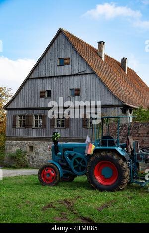 Altes deutsches Bauernhaus mit Oldtimer-Traktor Stockfoto