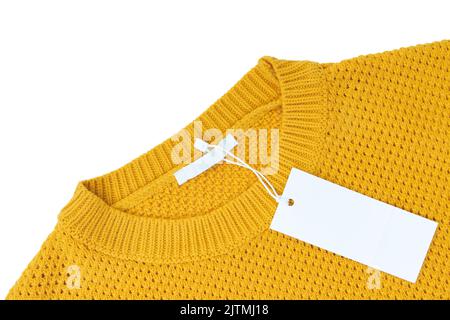 Weiße leere rechteckige Kleidung Tag, Label Mockup Vorlage auf gelb gestrickt Pullover isoliert auf weißem Hintergrund . Preisschild mit Kopierfläche f Stockfoto