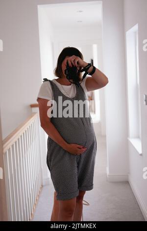 Eine Schwangerin nimmt Selfie-Fotos im Spiegel auf Stockfoto