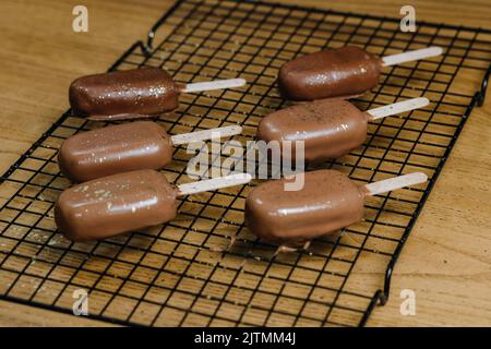 Eiskuchen mit Schokoladencreme. Chocolate Chip Cookies auf einem Stock in Form von Eis auf dem Tisch Stockfoto