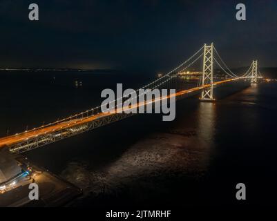 Luftaufnahme einer langen Hängebrücke, die nachts beleuchtet ist Stockfoto