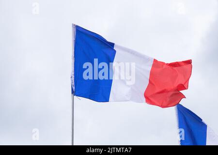 Die Flagge Frankreichs winkt vor weißem Hintergrund des bewölkten Himmels Stockfoto