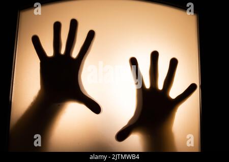 Gruseliges Bild von Händen hinter Glas, Horror-Geist hinter der Tür, Halloween-Konzept Stockfoto