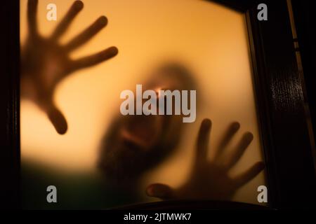 Gruseliges Bild von Händen hinter Glas, Horror-Geist hinter der Tür, Halloween-Konzept Stockfoto