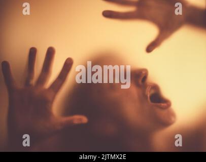 Gruseliges Bild von Händen hinter Glas, Horror-Geisterfrau hinter der Tür, Halloween-Konzept Stockfoto