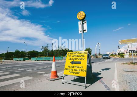Paphos, Zypern - 29. Okt 2014: Leere Straße mit Fußgängern können Fußgänger das gegenüber liegende Schild in der Stadt Paphos benutzen, wo Autos auf der Straße fahren Stockfoto