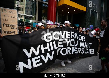 New York, Usa. 31. August 2022. Demonstranten halten ein Banner mit der Aufschrift „Gouverneur, während Sie auf den Tod der New Yorker warten“. Demonstranten wurden verhaftet, nachdem sie den Verkehr vor dem Büro von Gouverneur Kathy Hochul in New York City behindert hatten. Dies markiert den International Overdose Awareness Day und Aktivisten fordern Gouverneur Hochul auf, Exekutive Maßnahmen zu ergreifen, um Überdosis-Präventionszentren zu autorisieren und zu finanzieren. Kredit: SOPA Images Limited/Alamy Live Nachrichten Stockfoto