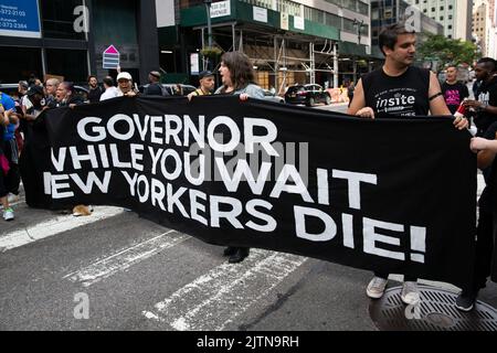 New York, Usa. 31. August 2022. Demonstranten halten ein Banner mit der Aufschrift „Gouverneur, während Sie auf den Tod der New Yorker warten“. Demonstranten wurden verhaftet, nachdem sie den Verkehr vor dem Büro von Gouverneur Kathy Hochul in New York City behindert hatten. Dies markiert den International Overdose Awareness Day und Aktivisten fordern Gouverneur Hochul auf, Exekutive Maßnahmen zu ergreifen, um Überdosis-Präventionszentren zu autorisieren und zu finanzieren. Kredit: SOPA Images Limited/Alamy Live Nachrichten Stockfoto