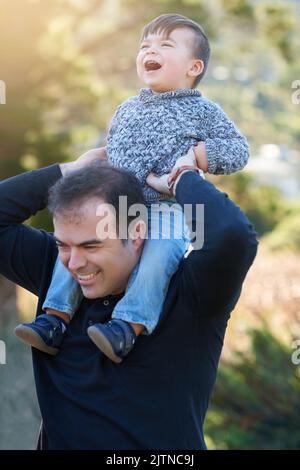 Die Welt ist viel heller vor Liebe. Ein Vater, der sich mit seinem kleinen Jungen draußen verbunden hat. Stockfoto