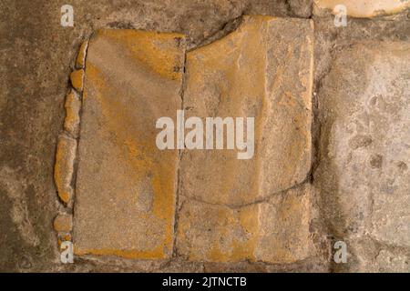 Abgenutzte glatte Natursteinplatte in einem antiken, alten, stark genutzten Steinboden aus römischer Zeit Stockfoto