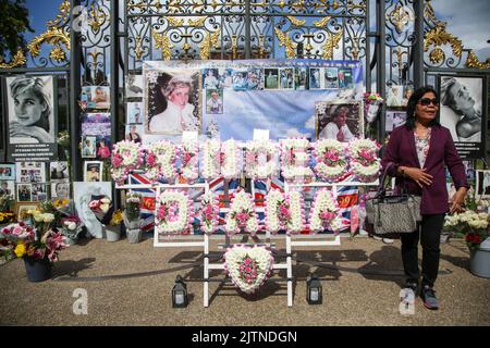 London, Großbritannien. 31. August 2022. Ein Wohlhabender posiert vor den Erinnerungsstücken vor dem Kensington Palace in London zum 25.. Todestag von Diana, Prinzessin von Wales, die in den frühen Morgenstunden des 31. August 1997 nach einem tödlichen Autounfall im Tunnel Pont de l'Alma im Krankenhaus Pitie-Salpetriere in Paris starb. Kredit: SOPA Images Limited/Alamy Live Nachrichten Stockfoto