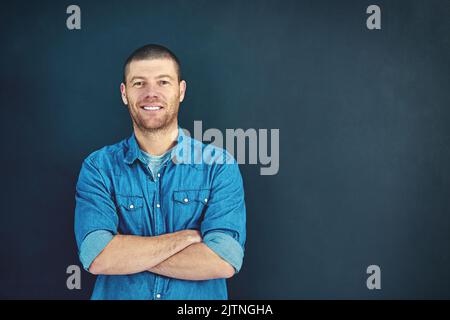 Ich habe das abgedeckt. Porträt eines selbstbewussten jungen Geschäftsmannes, der mit gefalteten Armen im Studio steht. Stockfoto